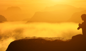 Woman meditating in a golden sunset illustrating ways to feed your soul and reconnect with inner joy."