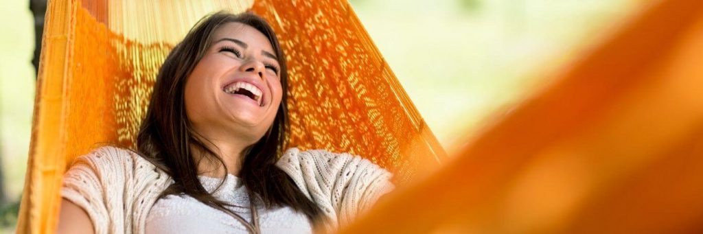 woman happy face lies on hammock laughing