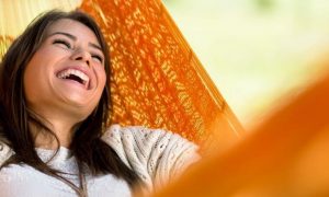 woman happy face lies on hammock laughing
