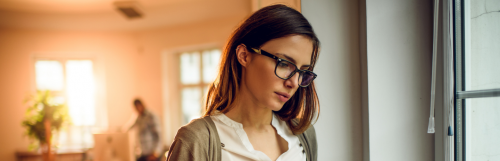 business woman wears black frame prescription glasses focuses on work in quiet office