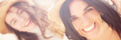 two women wears brown hats happily smiles in shiny sky