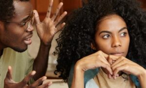 tanned skin man explains to curly black hair girl while she not listen with unhappy face