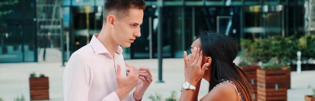 couple stands outside modern office building fights explains to each other