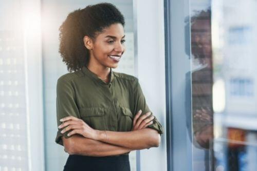Business woman in green shirt looking happy about creating positive change
