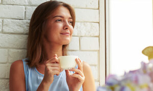 How to Overcome the Stress of Negative Thinking while woman is relaxing and drinking a cup of coffee