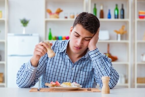 Sad man eating healthy food at home for lunch