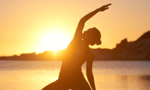 Women in golden sunrise doing yoga