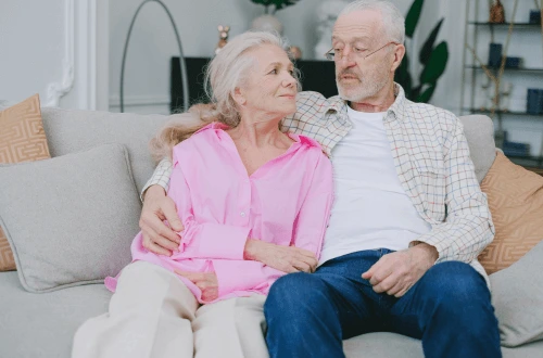 Elderly couple sitting on the couch having a conversation about death