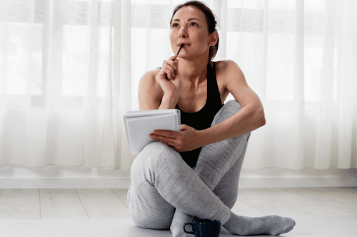 woman journaling for personal growth, wearing exercise gear