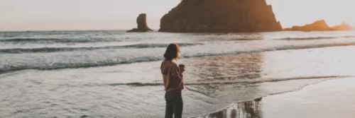 Woman on beach with coffee