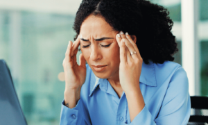 Digital stress caused for woman in blue shirt in office