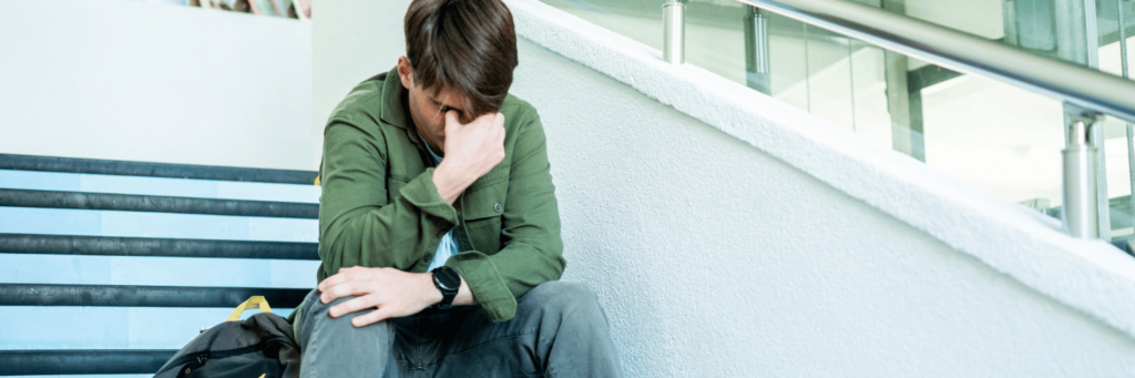 Stressed Student sitting on school stairs feeling academic pressure