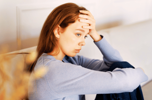 Breathwork for Stress and Anxiety to help a young woman sitting on a couch who is feeling overwhelmed
