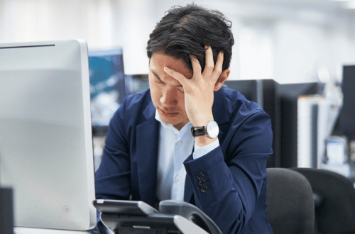 Man sitting at his desk at work, suffering from emotional exhaustion signs 