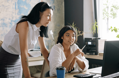 Woman showing emotional exhaustion signs as she is disengaged from talking about a colleague's work 