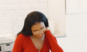 A woman in her forties smiling as she cooks in a bright modern kitchen, showing what an evening looks like without decision fatigue