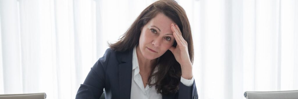 A professional woman suffering from psychosocial hazards at work