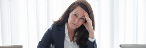 A professional woman suffering from psychosocial hazards at work