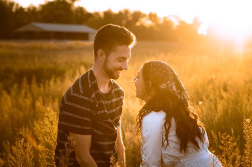A couple smiling at each other in warm evening light, showing what closeness can feel like beyond fear of abandonment