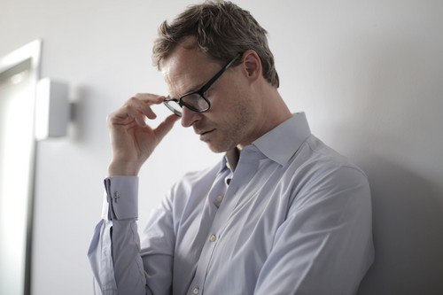 A man sitting still and hesitating over a decision, showing how fear of failure stops people before they start