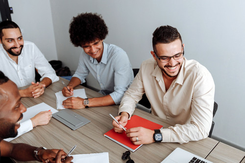 Colleagues at ease and smiling in a bright, modern office meeting, showing emotional resonance at work