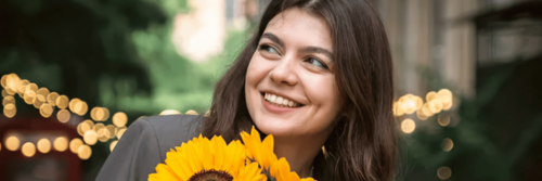 Colour and mood being uplifted as a happy woman holds yellow sunflowers
