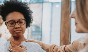 Emotional numbness is felt as a woman is comforted by another woman.