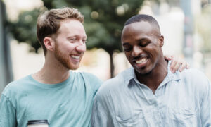 Two friends in their forties walking and laughing together in bright daylight, showing life after feeling stuck in life