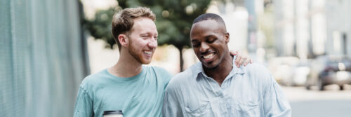 Two friends in their forties walking and laughing together in bright daylight, showing life after feeling stuck in life