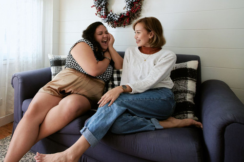 One woman listening closely to a friend in a bright modern room, showing support when feeling stuck in life