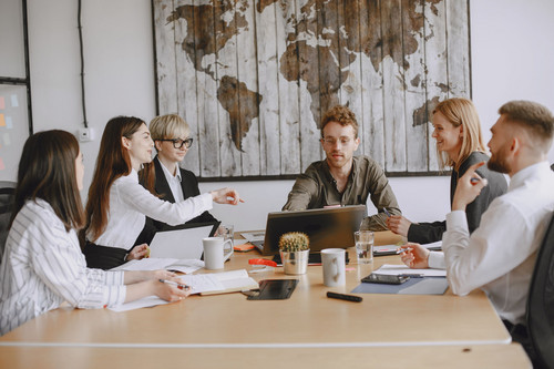 Colleagues at ease during a meeting in a bright modern office, showing a workplace where chronic stress symptoms are taken seriously
