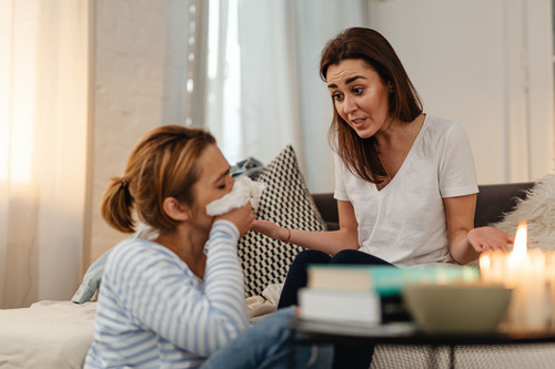 A man listening and comforting a friend in a bright modern room, showing how support begins when learning how to deal with grief and loss