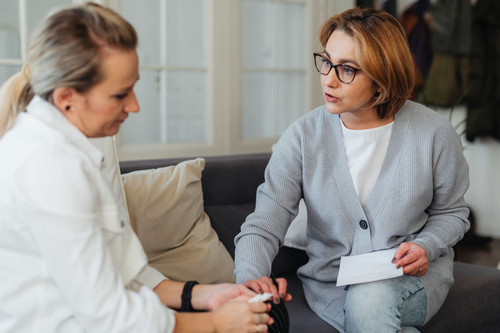 Two women in their forties talking honestly in bright daylight, the kind of conversation that loosens comparing yourself to others