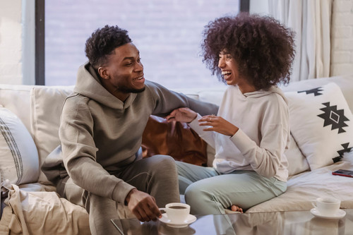A couple sitting on a sofa in daylight having an honest conversation about jealousy in relationships
