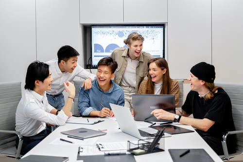 Colleagues at ease together in a bright modern office, showing how better stress and sleep show up at work
