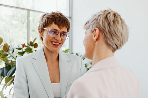 Colleagues at ease talking together in a bright modern office, showing a workplace that makes room for how to deal with grief and loss