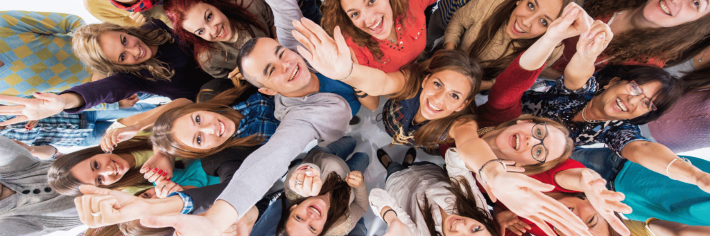 Collective energy of a group of people who have come together, raising their hands up to the air and looking upwards