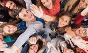 Collective energy of a group of people who have come together, raising their hands up to the air and looking upwards