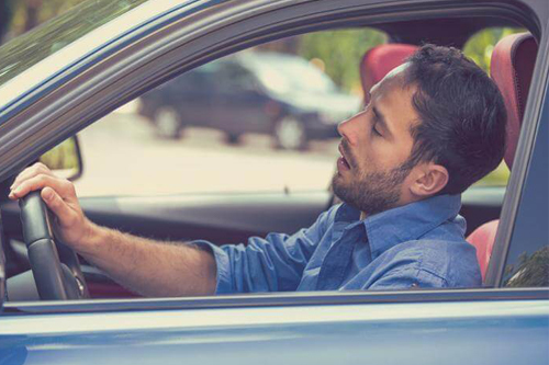 a man falling asleep in a car