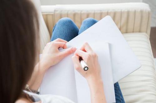 A woman writing on a notepad