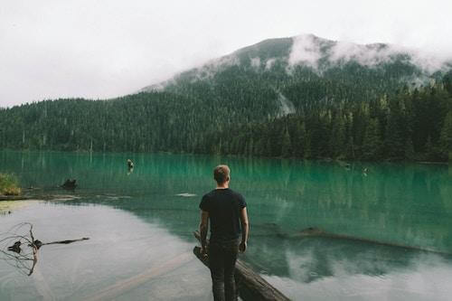 A man by clear water beautiful mountains and scenery