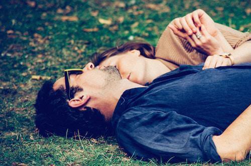 couple laying on grass together