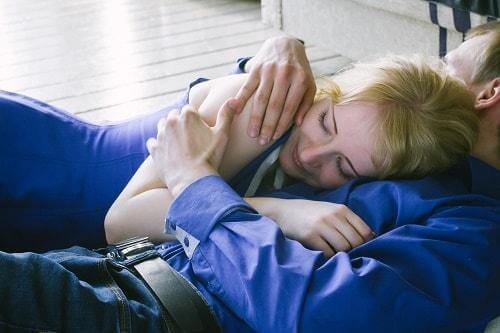 A couple in blue cuddling on the couch