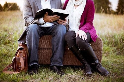 A couple reading together in a field