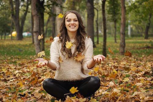 Woman playing with autumn leaves