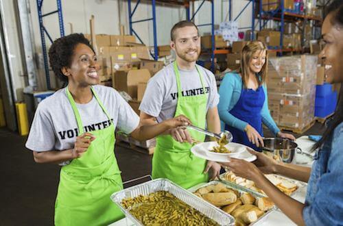 a group of people volunteering serving food