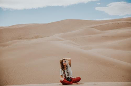 Woman sitting on sand dunes