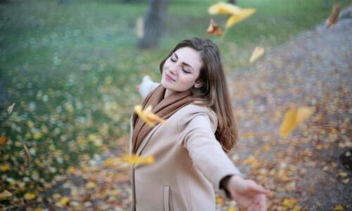 Woman swirling in autumn leaves