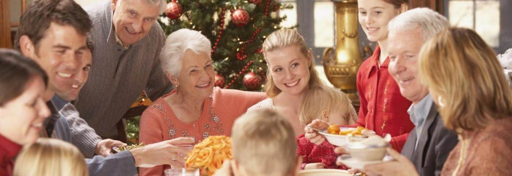 big family from different generations reunites sits in living room eating talking celebrating christmas beside christmas tree