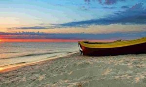 boat on sand nearby beach in blue sunset sky